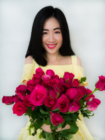 Beautiful girl is holding roses in her armsの写真素材