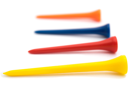 Row of colorful golf tees isolated on whiteの写真素材