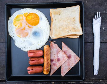 breakfast with eggs sausage and bread.の写真素材