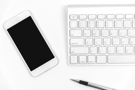 Top view of blank smart phone, keyboard and pen on white background.の写真素材