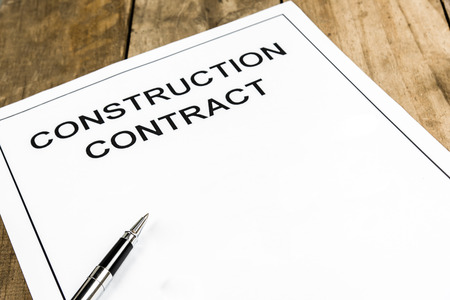 Pen on construction contract paper on wooden table.の写真素材