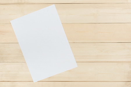 Blank white paper on wooden panel backgroundの写真素材