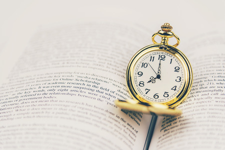 Vintage pocket watch on book with copy space.Time for study or reading concept.の写真素材