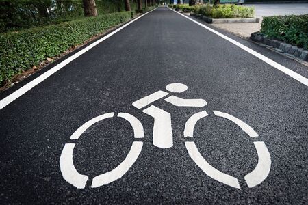 Close up shot of bicycle lane symbol on long asphalt road. Traffic sign