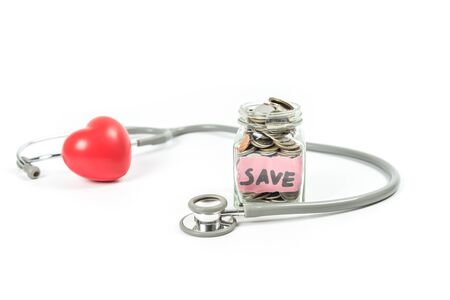 Jar of saving coin and stethoscope on white background.Saving money for medical conceptの写真素材
