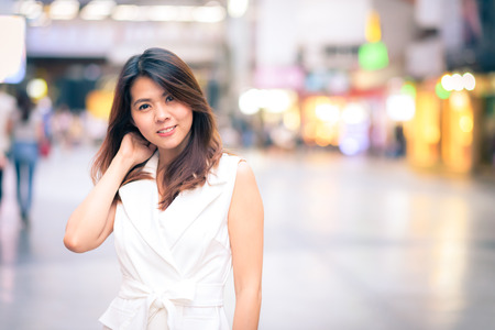 Portrait of young beautiful happy confident Asian woman smiling in city streetの写真素材