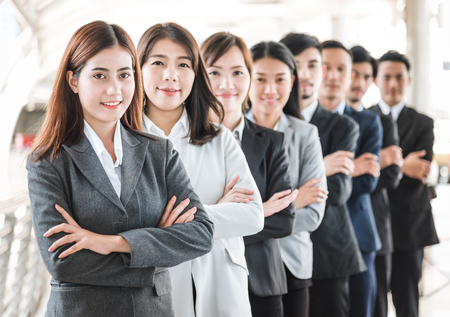 Happy smile Asian business team standing with cross arms in a row outdoorの写真素材