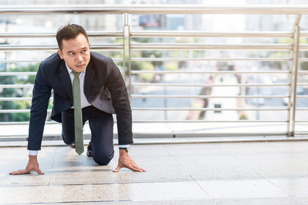 Confident Asian businessman ready to start his career or business with city in background. Business start concept.の写真素材