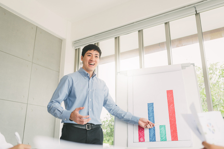 Young confident Asian businessman making a presentation to his colleagues in meeting roomの写真素材