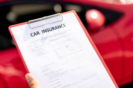 Close up shot of car insurance document with red car in backgroundの写真素材