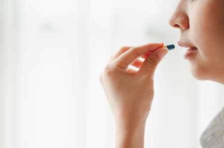Crop shot of side view of woman taking a capsule pillの写真素材