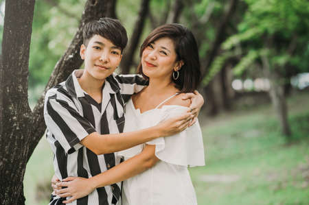 Two happy Asian lesbian couple in love embracing each other in park. Lgbt conceptの写真素材
