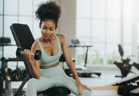 Portrait of young fitness sports woman workout with dumbbells in fitness gymの写真素材
