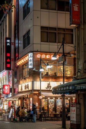 Ueno, Tokyo, Japan - Nov 28, 2023: Japanese street food izakaya restaurant with people sitting outside at nightのeditorial素材
