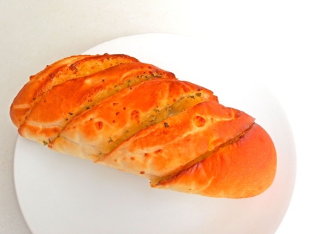 close up of garlic bread on white dish