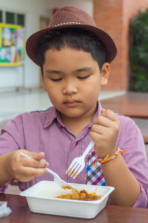 Cute boy enjoy eating foodの写真素材