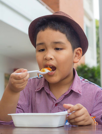 Cute boy enjoy eating foodの写真素材