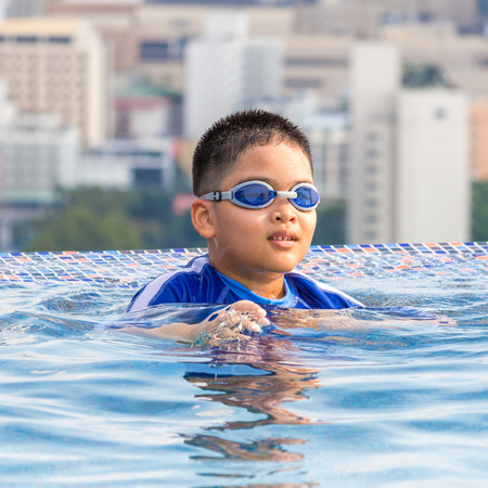 Cute little boy with his goggles on in swimming poolの写真素材