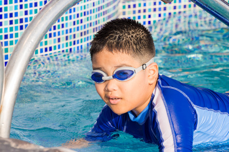 Cute little boy with his goggles on in swimming pool