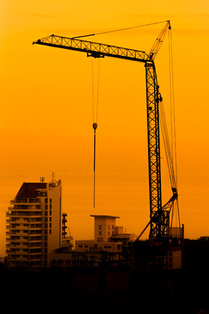 Industrial construction cranes and building silhouettesの写真素材