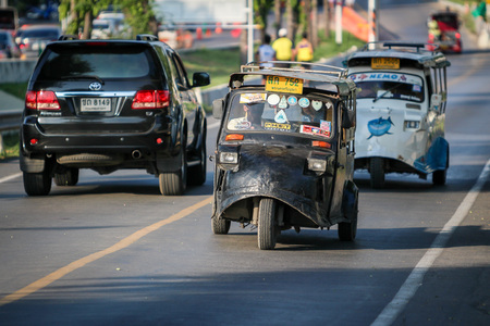 AYUTTHAYA, THAILAND - 6 DEC 2015: Tuk-Tuk driving on the road. It's a popular transportation for tourist in Ayutthaya historical city. on December 6 2015 in Ayutthaya Thailand.のeditorial素材