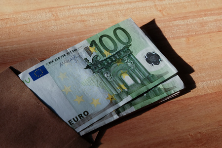 Euro banknotes in salary brown envelope.