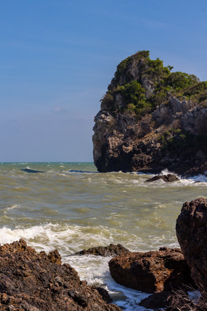 Waves and strong sea winds swept the rocks and shoals. Waves and sea breezes crash against rocks and shores.の写真素材