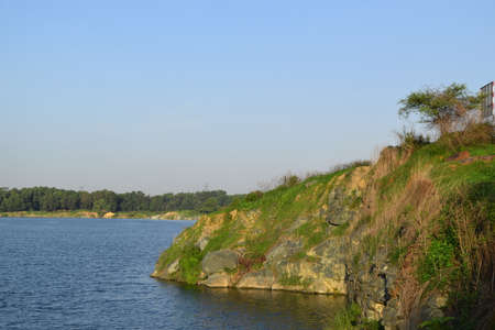 rocky lake with some stones and grass in the bank near Ho Chi Minh city, vietnamの写真素材