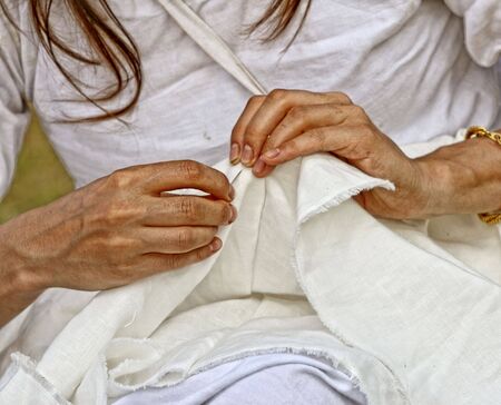 detail of sewing, old woman's hand at workの写真素材