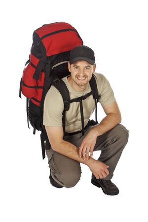 crounced travel man with big backpack on his back isolated on whiteの写真素材