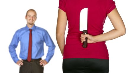 young caucasian man come back home and angry wife waiting for him with big knife behind her backの写真素材