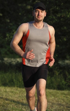 caucasian man run in a park at susnet