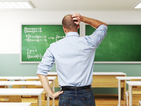 standing man thinking infront of blackboardの写真素材
