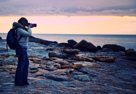 woman take a picture at sunset