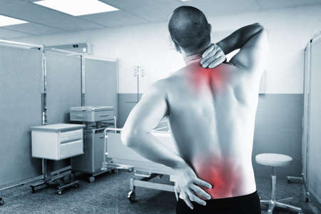 caucasian man with back pain with hospital background