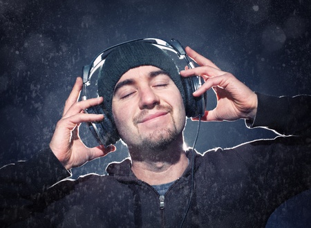 young man listen music with headphone under rainの写真素材