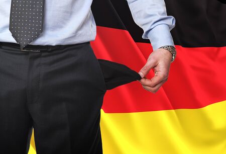 fine image of man showing his empty pocket with german flag backgroundの写真素材