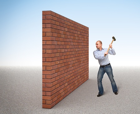 man with huge hammer and brick wallの写真素材