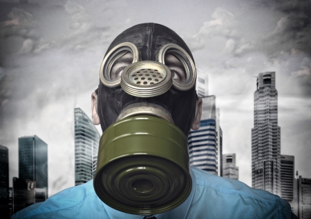 businessman with gas mask and town backgroundの写真素材