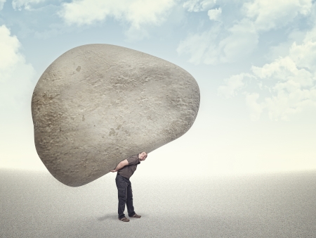 caucasian ma carry huge stone on his backの写真素材