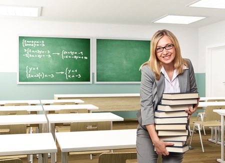 portrait of smiling teacher holding booksの写真素材