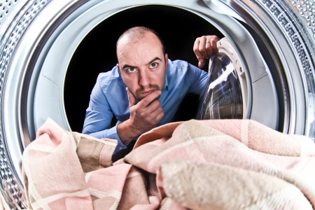 portrait of man view from washing machine insideの写真素材
