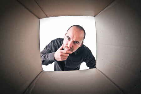 caucasian man look into a cardboard parcelの写真素材