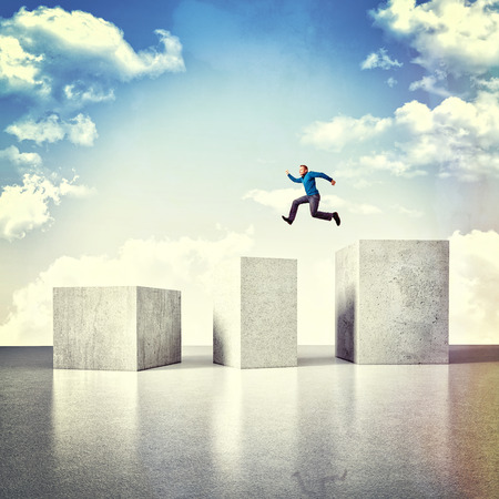 3d image of huge concrete block and jumping manの写真素材