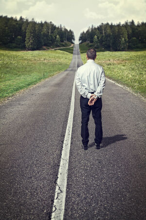 standing senior man and empty long roadの写真素材