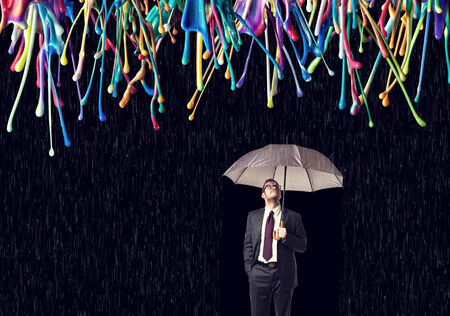 businessman with umbrella and color rainの写真素材