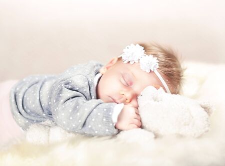 sleeping femal baby on classic white furの写真素材