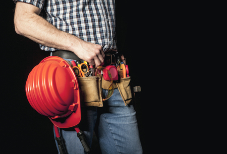 detail of handyman with leather toolsbelt and tools on dark backgroundの写真素材