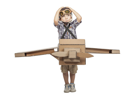 caucasian child play with cardboard airplane isolated on white backgroundの写真素材