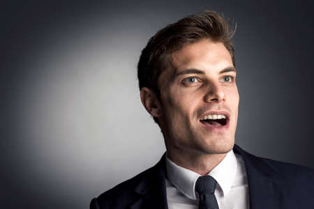 surprised caucasian businessman on gray backgroundの写真素材